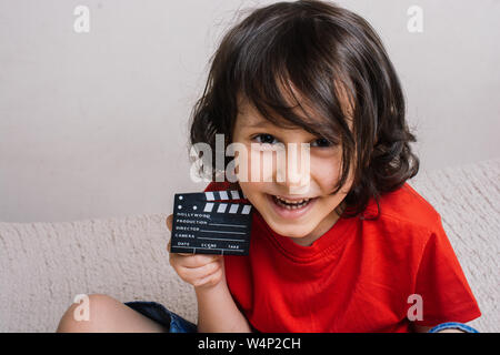 La production d'un film clapper board dans la main de petit garçon Banque D'Images