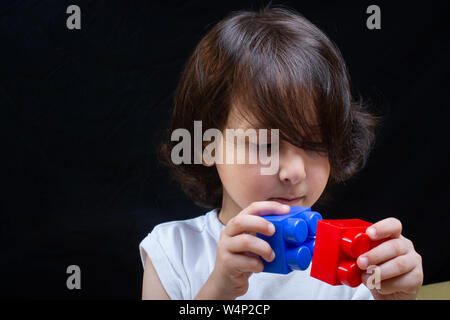 Les mains des enfants jouer avec des blocs colorés les blocs de lego Banque D'Images