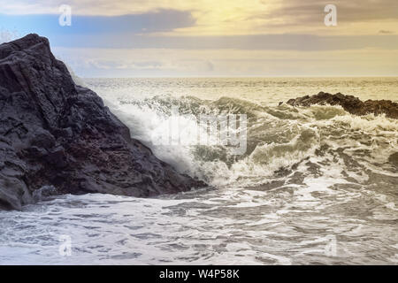 Vagues sur la côte rocheuse à l'heure d'or. L'île portugaise de Madère Banque D'Images
