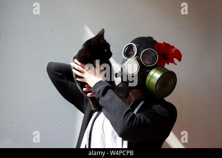 Fille dans un masque à gaz avec black cat. La dame Chat cosplay. Banque D'Images