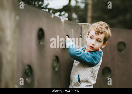 Portrait of boy escalade à jeux pour enfants Banque D'Images