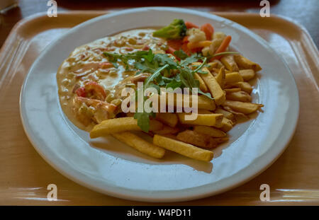 En vertu de la viande avec la sauce fried chips de pomme de terre sur un bac brun Banque D'Images