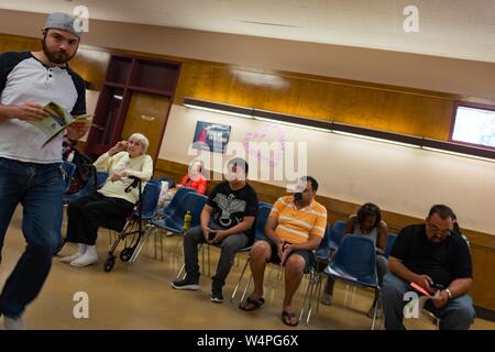 Les gens attendent dans des chaises pour leurs numéros à appeler, l'examen des manuels du conducteur, au California Department of Motor Vehicles (DMV) à Pleasanton, Californie, le 28 août 2018. () Banque D'Images