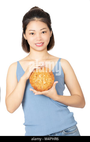 Belle femme chinoise habillé en vêtements décontractés tenant un gâteau de lune les aliments traditionnels chinois de la maison de vacances de la mi Automne Festival isolé sur un Banque D'Images