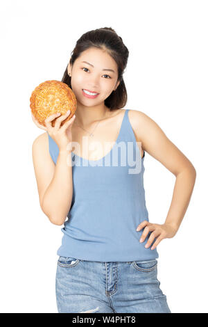 Belle femme chinoise habillé en vêtements décontractés tenant un gâteau de lune les aliments traditionnels chinois de la maison de vacances de la mi Automne Festival isolé sur un Banque D'Images