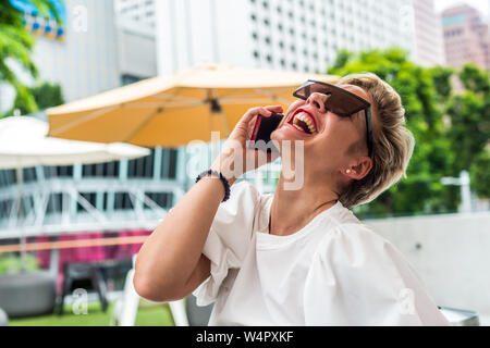 Femme d'affaires en plein air garden en utilisant le téléphone mobile à l'enveloppe rouge Banque D'Images