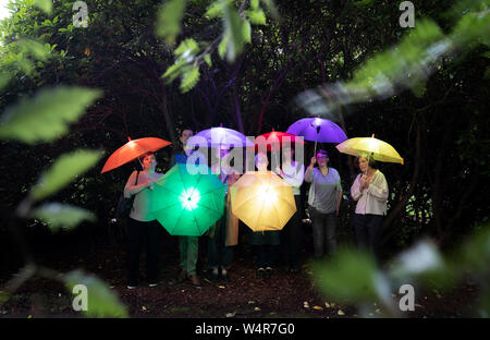 Les visiteurs franchissent le Royal Botanic Garden Edinburgh au crépuscule avec des parasols lumineux "Sonic", qui jouent le chant de Caithness et Sutherland. La pièce est l'un des plusieurs installations créés par des artistes de tout le Royaume-Uni, qui ont été chargés de produire une série de nouveaux visuels, sonores et sensoriels installations cinétiques pour le dessous de la couverture de l'événement d'art dans le cadre de l'Edinburgh Festival Fringe 2019. Banque D'Images