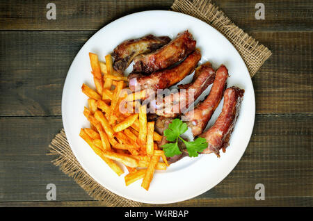 Côtes de porc en tranches grillées et frites sur plaque blanche, vue du dessus Banque D'Images