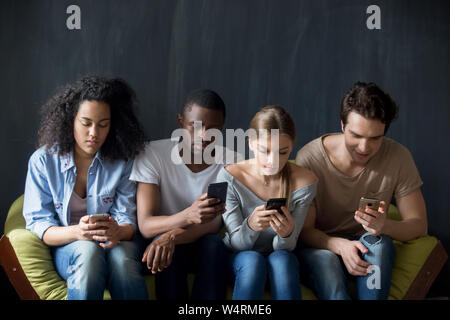 Une dépendance à l'aide de personnes de race mixte de la technologie des smartphones. Banque D'Images