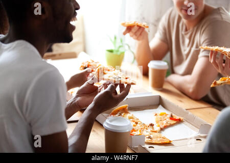 Close up portrait of diverse friends eating pizza. Banque D'Images