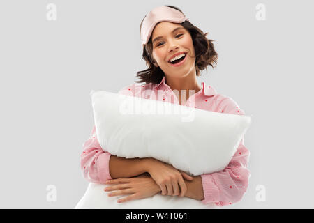 Femme avec coussin dans pajama et des yeux masque de sommeil Banque D'Images