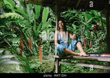 Femme assise sous un abri dans la jungle, Bali, Indonésie Banque D'Images