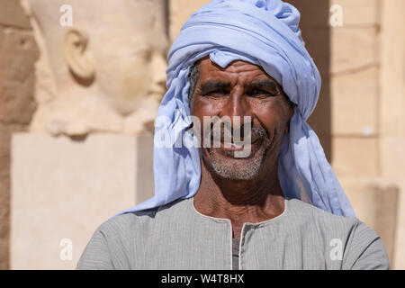 Guide arabe égyptien local près du temple de Louxor, Egypte. Les habitants proposent de guider les touristes dans les célèbres temples archéologiques. Banque D'Images