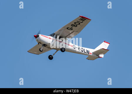 Avion avion léger Cessna 152 G-BOLW décollant de l'aéroport de Londres Southend, Essex, Royaume-Uni. General Aviation airplane flying in sky Banque D'Images