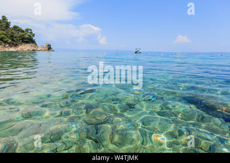 Vue magnifique sur l'eau turquoise de la mer d'été en journée sur la plage à destination de voyage Grèce. Banque D'Images