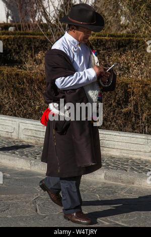 La Chine, Tibet, Lhasa, un pèlerin tibétain Khamba homme portant la lourde traditionnelle chuba ou chupa manteau avec très grands manches et bordée de peau de mouton. Banque D'Images