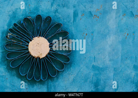 Daisy fleur fer sur fond bleu close up Banque D'Images