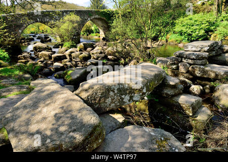 Rochers dans l'Est de la rivière Dart à Dartmeet, notamment les vestiges d'un vieux pont battant. Banque D'Images