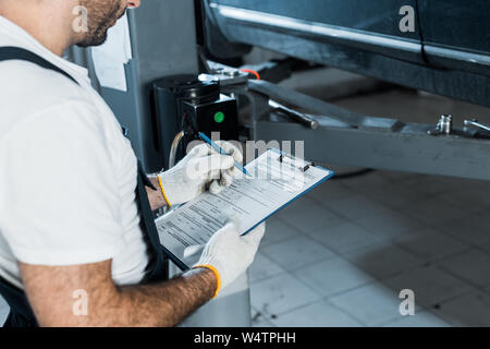 Portrait de auto mechanic holding clipboard and pen Banque D'Images