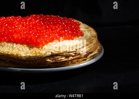 Pile de blinis poreux avec caviar rouge sur le dessus Banque D'Images