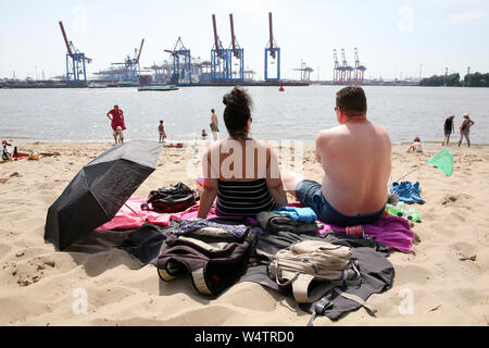 Hambourg, Allemagne. Le 25 juillet, 2019. Les touristes s'asseoir à la plage de températures Övelgönne en plein été. Une nouvelle vague de chaleur fait l'Allemagne avec la sueur des températures record. Credit : Bodo Marks/dpa/Alamy Live News Banque D'Images