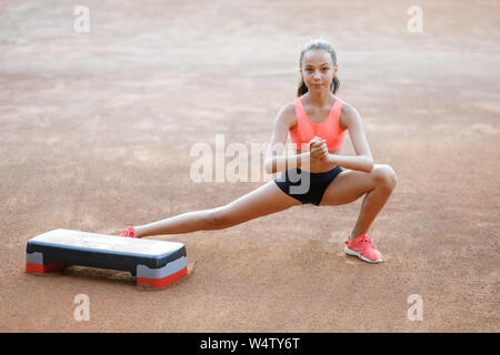 Un mignon, jolie adolescente effectue divers exercices de plein air. Vie Banque D'Images