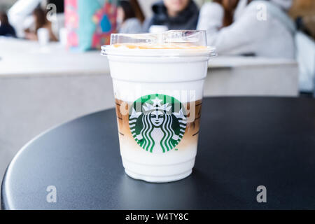Tokyo, Japon - 17 mars 2019 : Avis de café Starbucks tasse avec logo de la marque sur la table en face de Starbucks Coffee parc Ueno Onshi, Tokyo, Japon. Banque D'Images