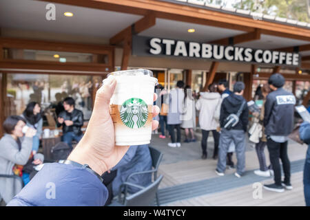 Tokyo, Japon - 17 mars 2019 : Starbucks Coffee cup avec logo de la marque en face de Starbucks Coffee parc Ueno Onshi pendant pink bloss Banque D'Images