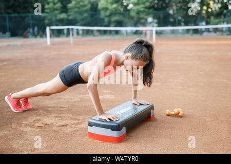 Un mignon, jolie adolescente effectue divers exercices de plein air. Vie Banque D'Images