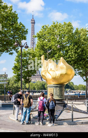 Les touristes debout devant la Flamme de la liberté à Paris, France, qui est devenu un monument à la Princesse Diana qui est mort dans le tunnel en dessous. Banque D'Images