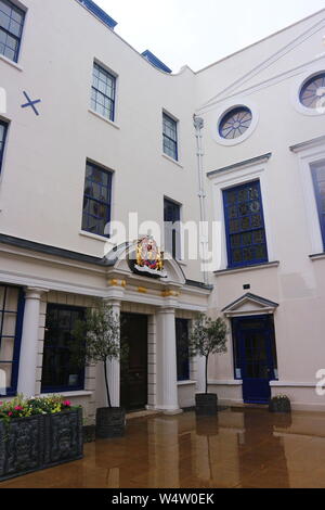 Une photo d'une maison avec des fenêtres et portes bleu et divers ornements d'or sur les murs. La photo a été prise à Londres, au Royaume-Uni par une matinée pluvieuse. Banque D'Images