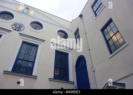 Une photo d'une maison avec des fenêtres et portes bleu et divers ornements d'or sur les murs. La photo a été prise à Londres, au Royaume-Uni par une matinée pluvieuse. Banque D'Images