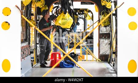 (190725) -- CHANGCHUN, 25 juillet 2019 (Xinhua) -- les travailleurs brancher les fils pour un transport d'un train léger sur rail lors d'un atelier de CRRC Changchun Véhicules ferroviaires Co., Ltd. à Changchun, capitale de la province de Jilin du nord-est de la Chine, 25 juillet 2019. Un train léger sur rail qui seront exportés vers Israël sort de la chaîne d'assemblage dans le nord-est de Changchun city chinois mardi. Le train, fabriqué par CRRC Changchun Véhicules ferroviaires Co., Ltd., sera utilisé pour la ligne rouge du système de métro léger dans la ville israélienne de Tel Aviv. La ligne de 23 km est schedul Banque D'Images