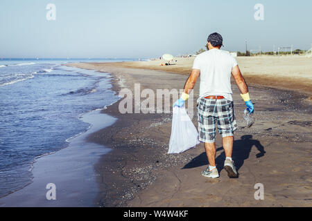 La collecte des déchets des bénévoles qui polluent l'océan dans un sac en plastique, des gens qui aident à conserver la nature propre et ramasser les matières plastiques à partir de la mer, faire du bénévolat Banque D'Images