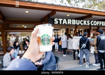 Tokyo, Japon - 17 mars 2019 : Starbucks Coffee cup avec logo de la marque en face de Starbucks Coffee parc Ueno Onshi pendant pink bloss Banque D'Images