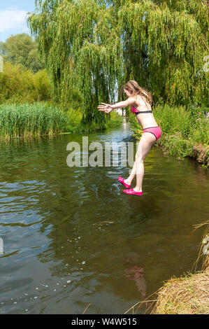 Fordingbridge, New Forest, Hampshire, Royaume-Uni, le 25 juillet 2019, la météo : une adolescente se refroidit en sautant à l'eau froide de la rivière Avon. La vague de chaleur actuelle et l'enregistrement d'aujourd'hui des pics de température la plus élevée pour le Royaume-Uni s'est rompu. Crédit : Paul Biggins/Alamy vivre Banque D'Images