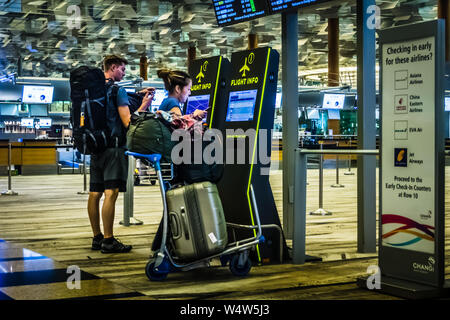 Singapour - Nov 11, 2018 : Tourist en utilisant la borne libre-service pour vérifier l'information de vol à l'aéroport de Changi, Terminal 3, Singapour. Banque D'Images