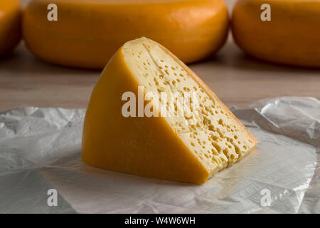 Morceau de fromage néerlandais Stolwijker avec les trous sur le papier Banque D'Images