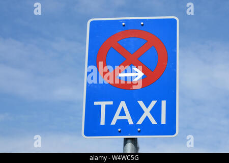 Soupir de trafic bleu rouge avec cercle traversé, flèche vers la droite et le mot "Taxi" écrit dessus, indiquant que les taxis ne sont pas autorisés à garer Banque D'Images