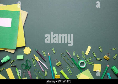 Retour à l'école. Fournitures scolaires et de couleur vert jaune sur fond gris, vue de dessus, copy space Banque D'Images