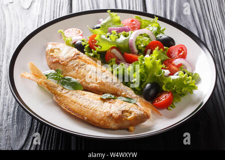 Rose méditerranéen dorado servi avec du citron et des légumes frais sur une assiette sur la table horizontale. Banque D'Images