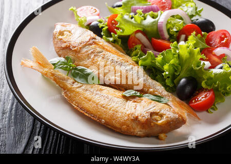 Rose fraîchement préparé avec du citron et du poisson dorado salade de légumes sur une assiette sur la table horizontale. Banque D'Images