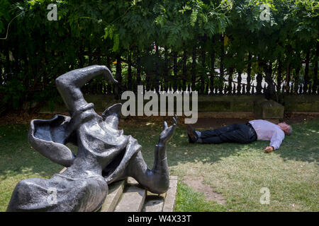 Comme les températures ne vague à des niveaux record - la journée la plus chaude de l'année jusqu'à présent - un Londonien dort dans l'ombre à côté de la sculpture intitulée Becket par Bainbridge Copnall (1973), dans la ville de Londres (le quartier financier de la capitale, alias le mille carré) au cours d'un repas chaud à l'étage en la Cathédrale St Paul Churchyard, le 25 juillet 2019, à Londres, en Angleterre. Banque D'Images