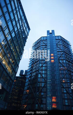 Un immeuble à Londres, UK dans une couleur bleuâtre et un grand nombre de fenêtres tourné en un faible angle de vue. La photo a été prise la nuit et un jour nuageux. Banque D'Images