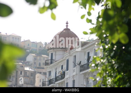 Maison coloniale française avec un dôme, encerclé par les feuilles des arbres dans la région de Bejaia Algerie Banque D'Images