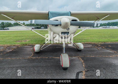Petite hélice avion stationné à l'extérieur à la recherche à l'avant jusqu'à proximité de la piste à un petit aéroport sur un jour nuageux Banque D'Images