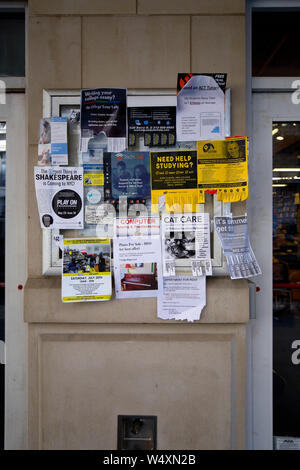 Un babillard communautaire à une librairie d'université rempli de publicité indésirable Banque D'Images