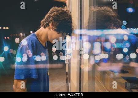 Déçu triste jeune homme désespéré se pencher la tête sur le mur de la ville Banque D'Images