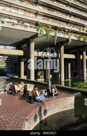 Les jeunes se rafraîchir et se relaxer à l'extérieur du centre d'exposition et de Barbican concert hall lors d'un jour très chaud à Londres, Royaume-Uni Banque D'Images