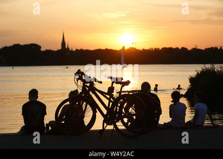 Hambourg, Allemagne. Le 25 juillet, 2019. À des températures autour de 30 degrés Celsius, les excursionnistes s'asseoir au coucher du soleil sur l'Alster à Hambourg. Une nouvelle vague de chaleur fait l'Allemagne avec la sueur des températures record. Credit : Bodo Marks/dpa/Alamy Live News Banque D'Images